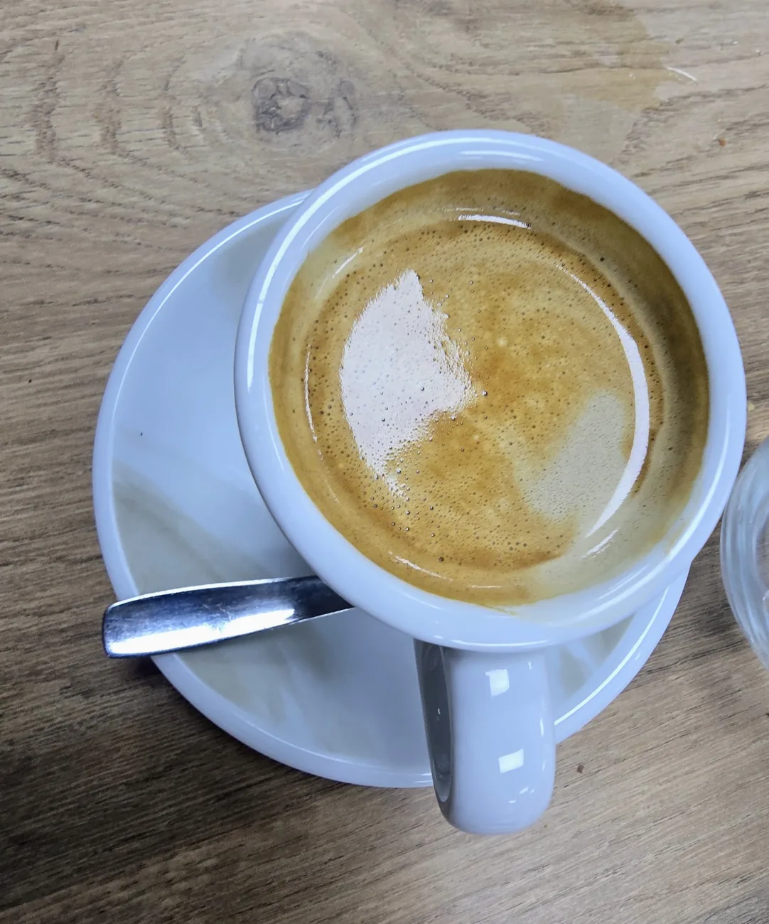 Café con leche con latte art en taza azul, servido en Xtreme Healthy Food