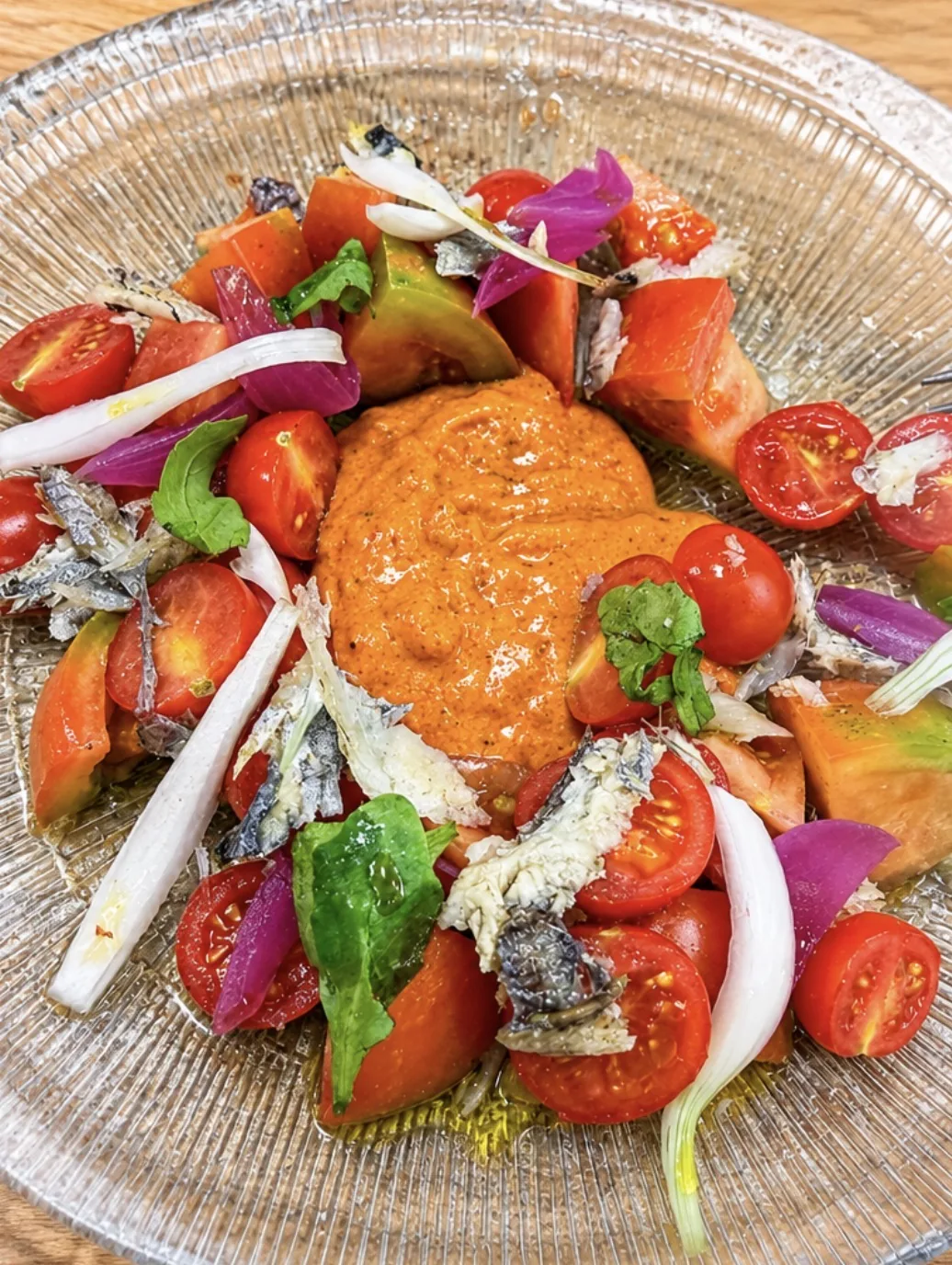 Ensalada de tomate, sardinas, cebolla y hojas verdes servida en Xtreme Healthy Food