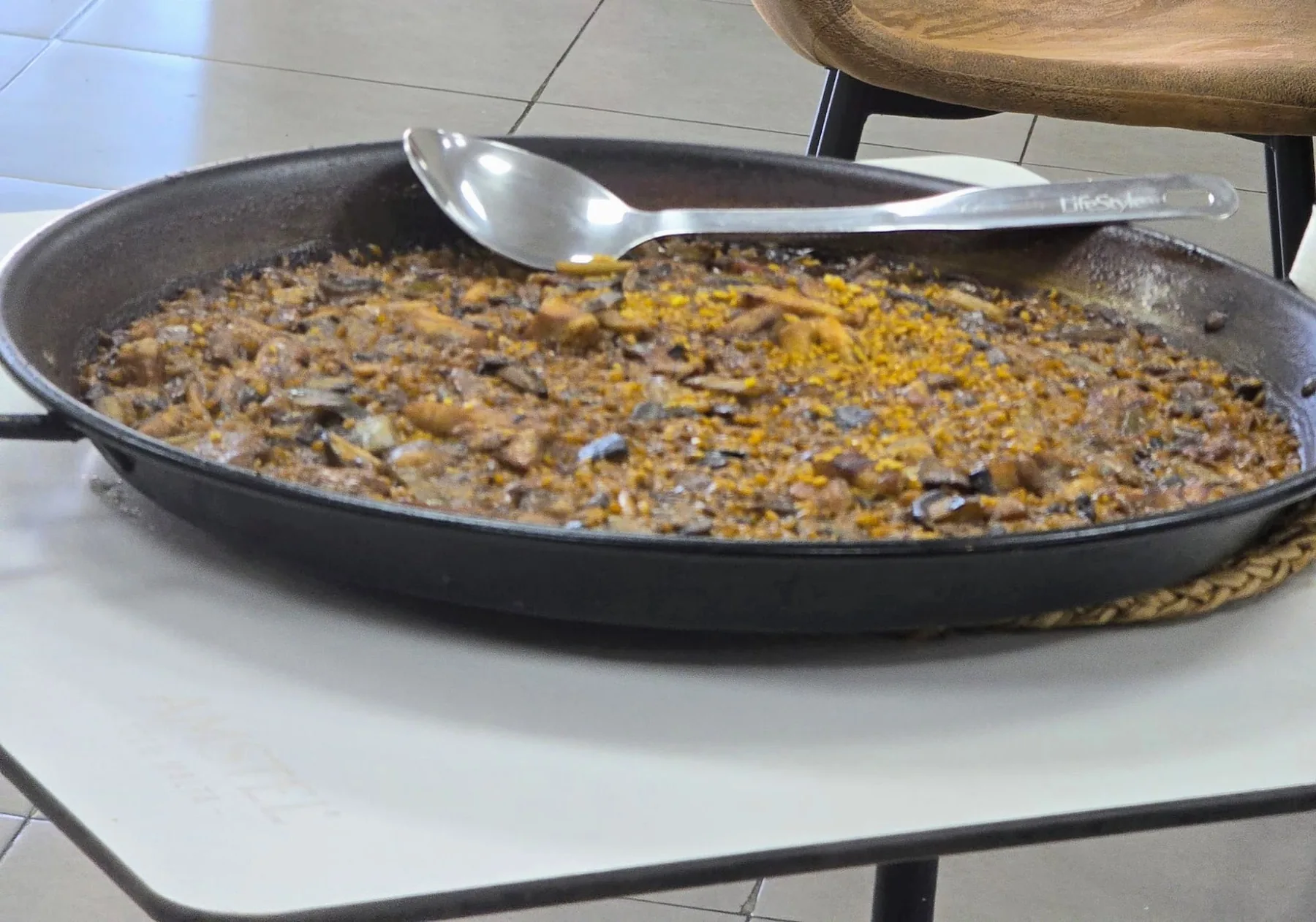 Paella de secreto con setas y ajos tiernos en la paella